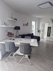 EngelsbrandFerienwohnung Alona的客厅配有白色的桌子和椅子