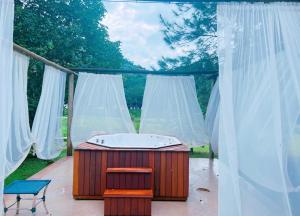特雷索波利斯Pousada Jupter的浴缸位于带白色窗帘的庭院内