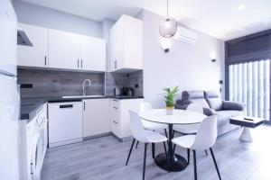 瓦伦西亚Patacona by Concept Flats的厨房以及带桌椅的起居室。