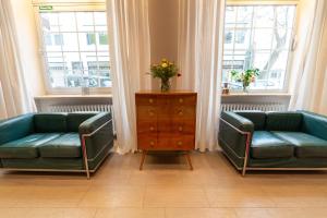 慕尼黑Hotel Carlton Munich的客厅设有两张绿色沙发,配有窗户