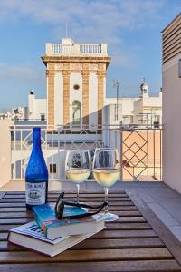 加的斯VG - Villa de Andas suites的两杯葡萄酒和一张桌子上的书