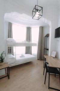 瓦伦西亚Clink Rooms & Flats的客房设有两张双层床和一张书桌。