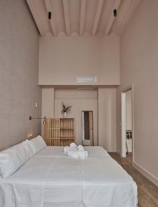 加的斯VG - Villa de Andas suites的一间卧室配有一张带白色床单的大床