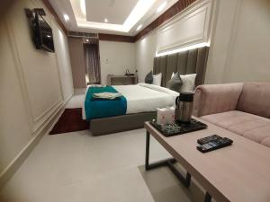 坎普尔Hotel Gagan Plaza的酒店客房,配有床和沙发