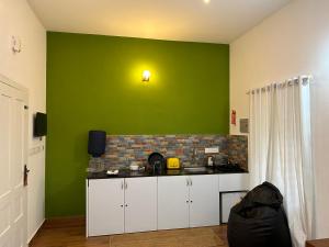 瓦亚纳德Silver Oak By Exuberance Stays (Independent Holiday Home)的厨房设有绿色墙壁和台面