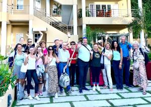 博瓦隆热带的向往公寓式酒店的一群人站在一座建筑物前摆着一张照片