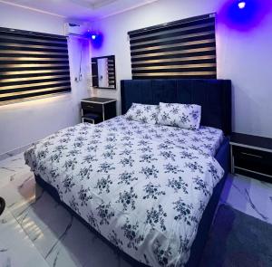 卡拉巴尔Signature Residence的一间卧室配有一张带蓝色和白色棉被的床