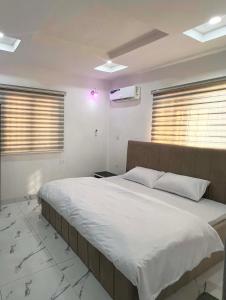 卡拉巴尔Signature Residence的卧室配有一张带白色床单和窗户的大床。