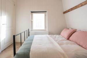 阿姆斯特丹Cozy B&B Prinsengracht的一间卧室配有一张带粉色和绿色床单的床