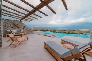 圣安娜纳克索斯Naxos Privilege Villas的一个带桌椅的庭院和一个游泳池