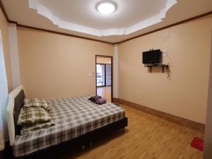 考陶Boonsong Guest House的一间卧室配有一张床和一台平面电视