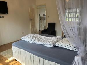 基苏木Cinnamon House的一间卧室配有带窗帘的床和椅子