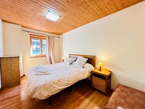 陶尔Apartamento Sant Climent Timmo的一间卧室设有一张床和木制天花板