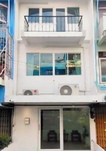 曼谷Whole 3-storey house right in the local community.的白色的房子设有窗户和阳台