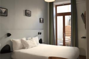 马赛Hôtel Saint Louis - Vieux Port的卧室配有白色的床和窗户。