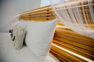 KórinthosYARD- Family retreat的一张带白色枕头和木制床头板的床