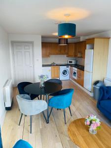 克利夫登Apartment 2 @ Clifden Bay Apartments的厨房以及带桌椅的用餐室。