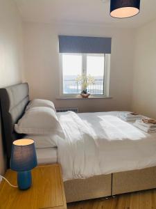 克利夫登Apartment 2 @ Clifden Bay Apartments的卧室设有一张白色大床和一扇窗户。