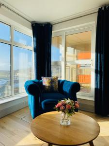 克利夫登Apartment 2 @ Clifden Bay Apartments的客厅配有蓝色的沙发和桌子