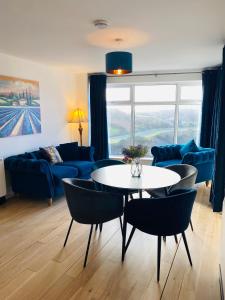 克利夫登Apartment 2 @ Clifden Bay Apartments的客厅配有桌子和蓝色沙发