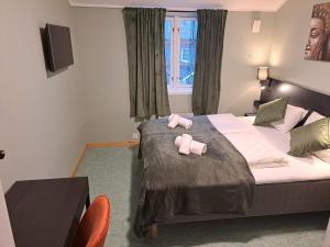 萨普斯堡Tune Hotell Sarpsborg的一间卧室配有两张床,上面有粉红色的毛巾
