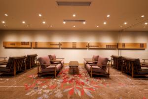 高山Hida Takayama Onsen Takayama Green Hotel的一间设有桌椅和墙壁的等候室