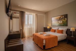 科英布拉河畔套房酒店的配有一张床和一台平面电视的酒店客房