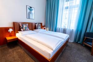 慕尼黑Hotel Carlton Munich的一间卧室配有一张带蓝色窗帘的大床