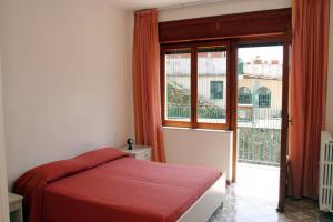 拉维罗Residence Le Villette的一间卧室设有红色的床和大窗户