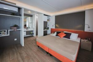 瓦达Camping Campo dei Fiori的一间卧室配有一张带橙色床头板的大床
