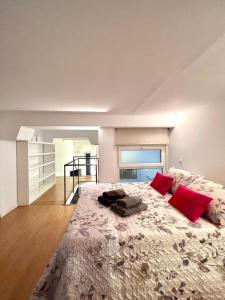 马德里Excelente loft en Trafalgar的一间卧室配有一张大床和两个红色枕头