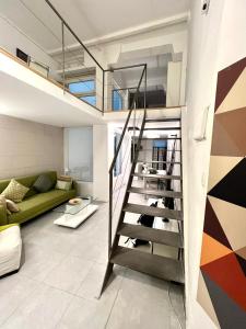 马德里Excelente loft en Trafalgar的客厅的楼梯,带绿色沙发