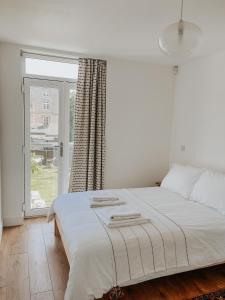 赖德East Street Beach House - luxury living by the sea的卧室内的一张白色床,设有窗户