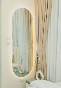 河内EDEN RESIDENCE的一间带镜子的浴室和鲜花窗户