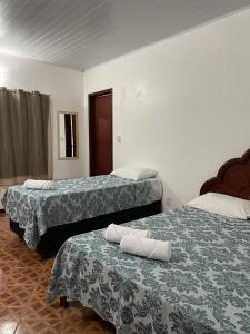 戈亚斯州上帕莱索Pousada Recanto dos Sonhos的两张位于酒店客房的床,配有毛巾