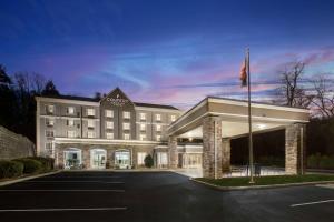 阿什维尔Country Inn & Suites by Radisson Asheville Downtown Tunnel Road的停车场内挂有旗帜的酒店大楼