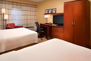 阿灵顿海茨Comfort Inn & Suites的酒店客房设有两张床和一张书桌及电视