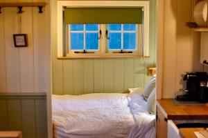BurphamThe Deer Hut的一间卧室设有一张床和一个窗口