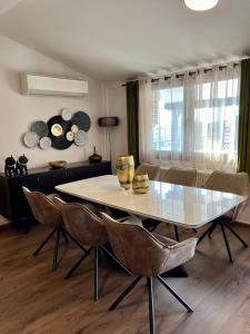 亚历山德鲁波利斯ZEN Apartments的一间配备有白色桌椅的用餐室