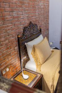舍夫沙万卡萨萨比拉旅馆的一间卧室设有一张床和砖墙