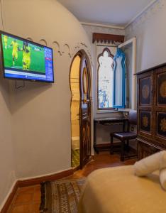 舍夫沙万卡萨萨比拉旅馆的一间墙上配有电视的房间和一间卧室