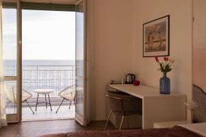 萨莱诺Cas’ A Mare - Beachfront Luxury Suites的一间卧室设有一张书桌,享有海景