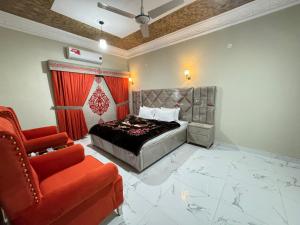 伊斯兰堡Decent Lodge Guest House F-10的一间卧室配有一张床和一张红色椅子