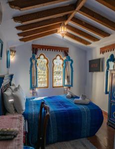 舍夫沙万卡萨萨比拉旅馆的一间卧室设有蓝色的床和2个窗户。