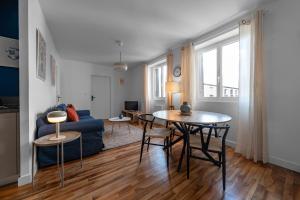 克莱蒙费朗Résidence Léon Blum - Appartements design - Parking的客厅配有桌子和蓝色沙发