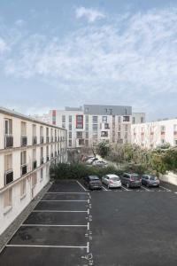 克莱蒙费朗Résidence Léon Blum - Appartements design - Parking的停车场,停车场的汽车停在大楼前