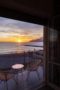 萨莱诺Cas’ A Mare - Beachfront Luxury Suites的阳台配有桌椅,享有海景。
