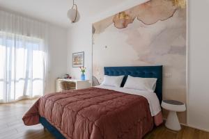萨莱诺Cas’ A Mare - Beachfront Luxury Suites的一间卧室配有一张大床和蓝色床头板