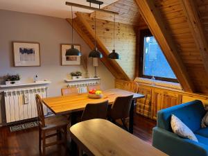 萨拉尔杜Eth Céu de Salardú的一间带木桌和蓝色沙发的用餐室