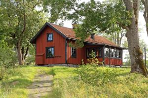 韦姆德Siggesta Gård的田野里的一个红色房子